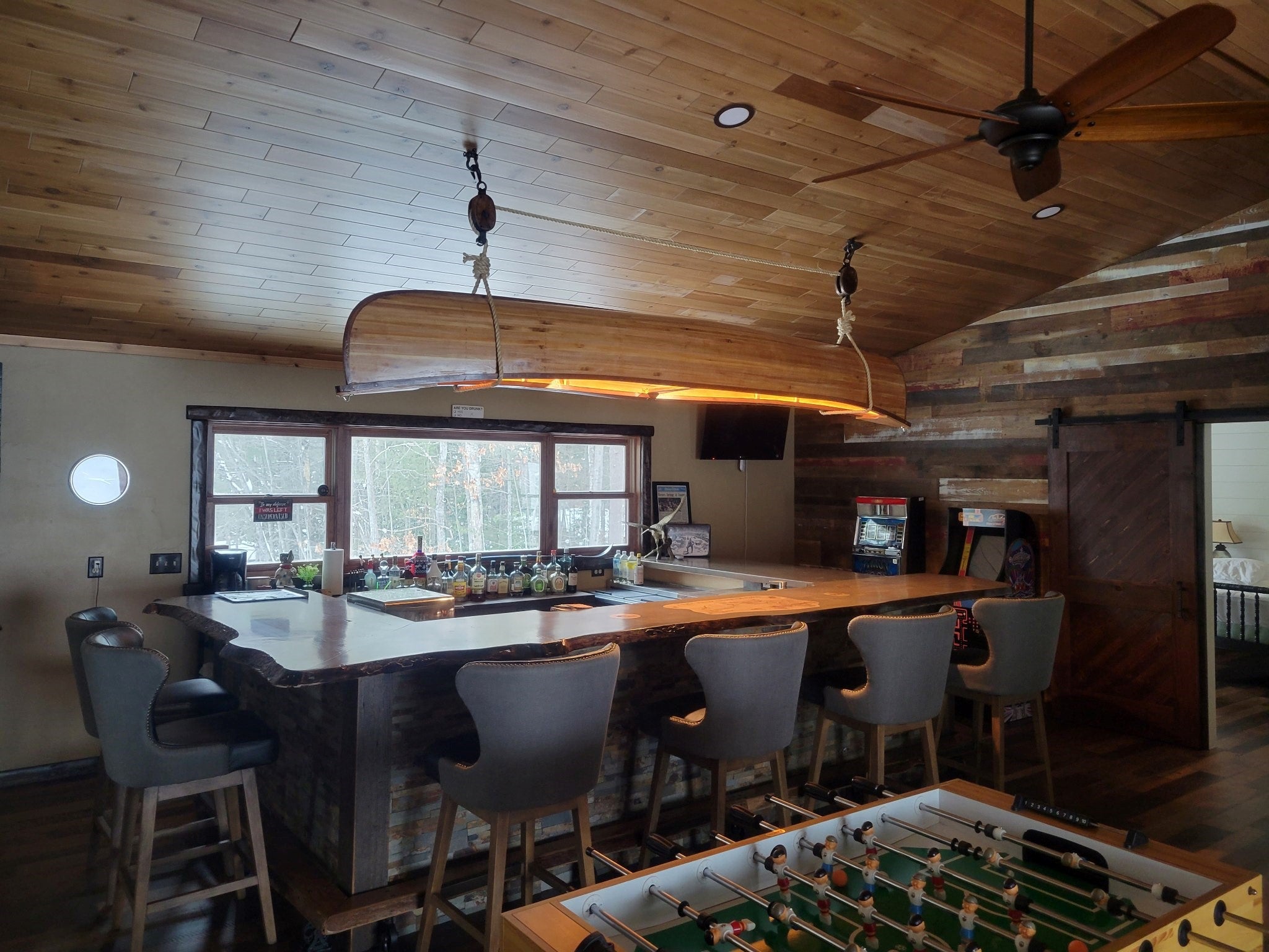 Cedar strip canoe made using 6 ounce fiberglass cloth hanging over bar top with sink.