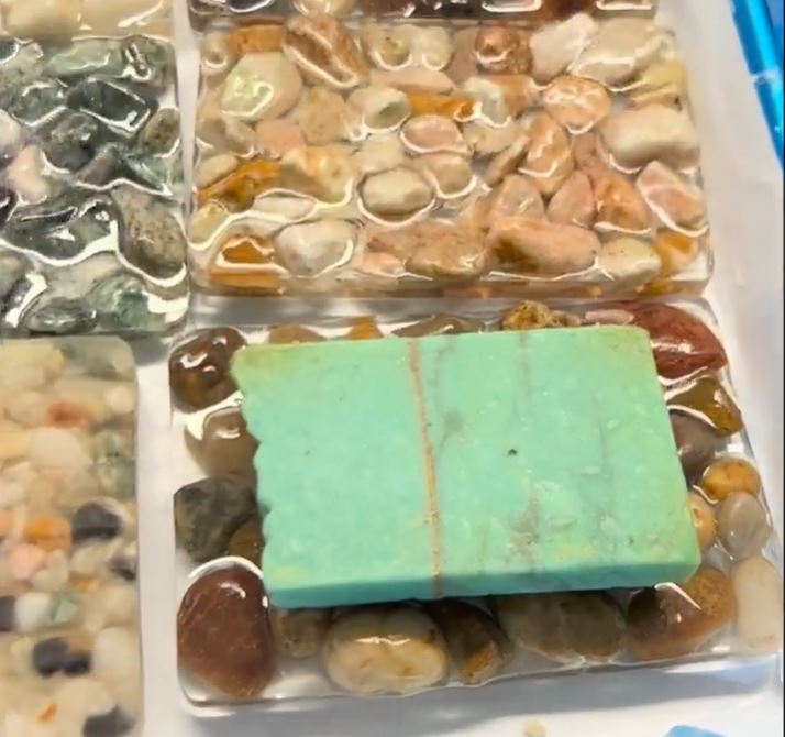 Green bar soap sitting on epoxy resin and stone soap dish.